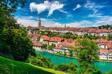 Bern eski şehir merkezi ve Aare, Bern nehri üzerindeki Nydeggbrucke köprüsü manzaralı. Bern, güneşli bir günde Aare Nehri 'nin şehrin etrafında aktığı eski bir kasaba, Bern, İsviçre.