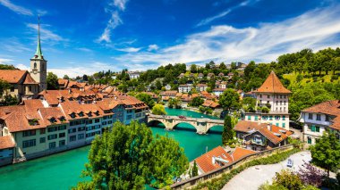 Bern eski şehir merkezi ve Aare, Bern nehri üzerindeki Nydeggbrucke köprüsü manzaralı. Bern, güneşli bir günde Aare Nehri 'nin şehrin etrafında aktığı eski bir kasaba, Bern, İsviçre.