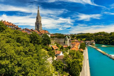 Bern eski şehir merkezi ve Aare, Bern nehri üzerindeki Nydeggbrucke köprüsü manzaralı. Bern, güneşli bir günde Aare Nehri 'nin şehrin etrafında aktığı eski bir kasaba, Bern, İsviçre.