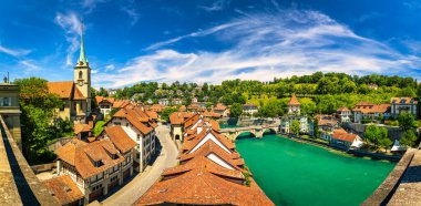 Bern eski şehir merkezi ve Aare, Bern nehri üzerindeki Nydeggbrucke köprüsü manzaralı. Bern, güneşli bir günde Aare Nehri 'nin şehrin etrafında aktığı eski bir kasaba, Bern, İsviçre.