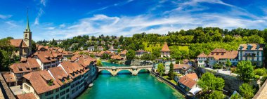 Bern eski şehir merkezi ve Aare, Bern nehri üzerindeki Nydeggbrucke köprüsü manzaralı. Bern, güneşli bir günde Aare Nehri 'nin şehrin etrafında aktığı eski bir kasaba, Bern, İsviçre.