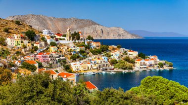 View of the beautiful greek island of Symi (Simi) with colourful houses and small boats. Greece, Symi island, view of the town of Symi (near Rhodes), Dodecanese.