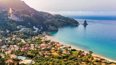 Yunanistan 'ın Korfu adasındaki Agios Gordios egzotik plajı. Agios Gordios plajı, Korfu adası, Yunanistan. Agios Gordios plajının panoramik manzarası, kumlu deniz kıyıları, plaj şemsiyeleri ve şezlonglar..