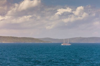 Akşamları denizde yüzen yelkenli, dağların arka planında, lüks yaz maceraları, Akdeniz, Hırvatistan 'da aktif tatil. Denizde beyaz yelkenli lüks bir yatta yelken açmak.. 