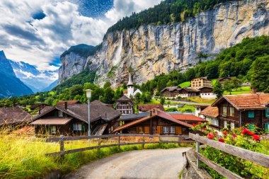 Ünlü kilisesi ve Staubbach şelalesi ile turistik alp köyü Lauterbrunnen 'in inanılmaz yaz manzarası. Konum: Lauterbrunnen Köyü, Berner Oberland, İsviçre, Avrupa.