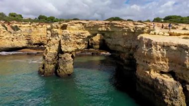 Okyanusun üzerindeki doğal kemer, Arco de Albandeira, Algarve, Portekiz. Praia de Albandeira 'daki taş kemer, Lagoa, Algarve, Portekiz. Portekiz 'in Algarve kentindeki doğal kemer Arco da Albandeira manzarası.