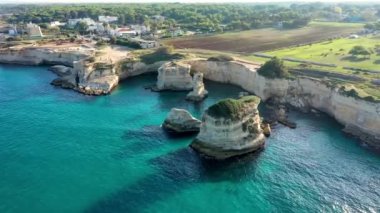 İtalya 'nın Puglia bölgesinde Torre Sant Andrea, Salento sahilinde kayalık kayalık ve yığınlar (Faraglioni) ile büyüleyici deniz manzarası. Sant 'Andrea, Salento, Apulia, İtalya' nın güzel kayalıkları ve deniz yığınları