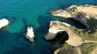 İtalya 'nın Puglia bölgesinde Torre Sant Andrea, Salento sahilinde kayalık kayalık ve yığınlar (Faraglioni) ile büyüleyici deniz manzarası. Sant 'Andrea, Salento, Apulia, İtalya' nın güzel kayalıkları ve deniz yığınları