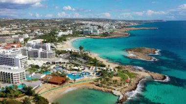 Kıbrıs Rum Kesimi 'nin Ayia Napa kentindeki güzel Nissi plajının hava manzarası. Kıbrıs 'ın Ayia Napa kentindeki Nissi plajı. Kıbrıs Rum Kesimi 'nin Aiya Napa kentindeki gök mavisi bir su manzarası ve Nissi plajı.