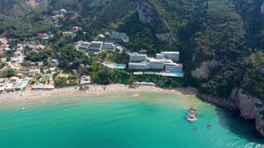 Yunanistan 'ın Korfu adasındaki Agios Gordios egzotik plajı. Agios Gordios plajı, Korfu adası, Yunanistan. Agios Gordios plajının panoramik manzarası, kumlu deniz kıyıları, plaj şemsiyeleri ve şezlonglar..