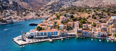 Renkli evler ve küçük teknelerle güzel Yunan adası Symi 'nin (Simi) havadan manzarası. Yunanistan, Suriye adası, Suriye (Rodos yakınlarında), Dodekanese manzarası.