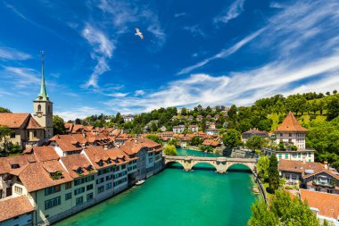 Bern eski şehir merkezi ve Aare, Bern nehri üzerindeki Nydeggbrucke köprüsü manzaralı. Bern, güneşli bir günde Aare Nehri 'nin şehrin etrafında aktığı eski bir kasaba, Bern, İsviçre.
