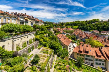 Bern eski şehir merkezi ve Aare, Bern nehri üzerindeki Nydeggbrucke köprüsü manzaralı. Bern, güneşli bir günde Aare Nehri 'nin şehrin etrafında aktığı eski bir kasaba, Bern, İsviçre.