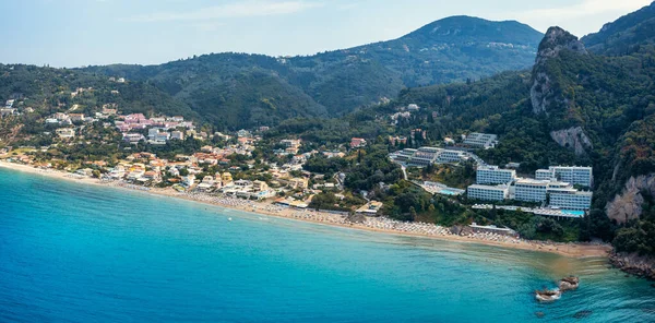 Yunanistan 'ın Korfu adasındaki Agios Gordios egzotik plajı. Agios Gordios plajı, Korfu adası, Yunanistan. Agios Gordios plajının panoramik manzarası, kumlu deniz kıyıları, plaj şemsiyeleri ve şezlonglar..