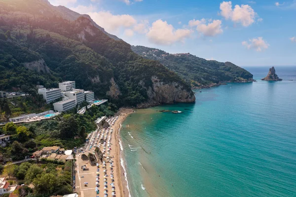 Yunanistan 'ın Korfu adasındaki Agios Gordios egzotik plajı. Agios Gordios plajı, Korfu adası, Yunanistan. Agios Gordios plajının panoramik manzarası, kumlu deniz kıyıları, plaj şemsiyeleri ve şezlonglar..