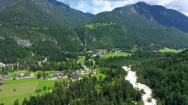 Slovenya 'nın Gozd Martuljek kasabası yazın arka planda güzel doğa ve dağlarla. Slovenya 'daki Gozd Martuljek' in yanındaki dağ manzarası, Gozd Martuljek 'in tepesinden manzara.