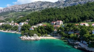 Hırvatistan, Makarska Riviera 'da güzel Brela. Adriyatik Denizi, turkuaz, temiz su ve beyaz kumla. Hırvatistan 'ın Makarska Riviera, Dalmaçya bölgesindeki Brela sahili ve liman manzarası.