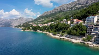 Hırvatistan, Makarska Riviera 'da güzel Brela. Adriyatik Denizi, turkuaz, temiz su ve beyaz kumla. Hırvatistan 'ın Makarska Riviera, Dalmaçya bölgesindeki Brela sahili ve liman manzarası.