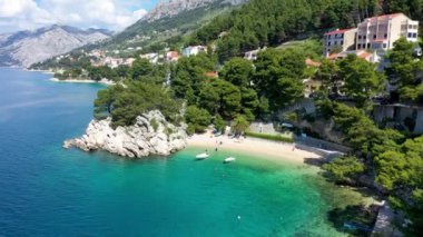 Hırvatistan 'ın Makarska Riviera kentinin Brela kentindeki güzel Podrace plajının muhteşem hava manzarası. Hırvatistan 'ın Makarska Riviera, Brela ve Dalmaçya bölgesindeki Podrace plajı ve liman manzarası.