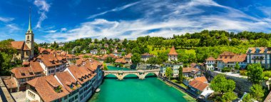 Bern eski şehir merkezi ve Aare, Bern nehri üzerindeki Nydeggbrucke köprüsü manzaralı. Bern, güneşli bir günde Aare Nehri 'nin şehrin etrafında aktığı eski bir kasaba, Bern, İsviçre.