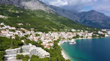 Hırvatistan, Makarska Riviera 'da güzel Brela. Adriyatik Denizi, turkuaz, temiz su ve beyaz kumla. Hırvatistan 'ın Makarska Riviera, Dalmaçya bölgesindeki Brela sahili ve liman manzarası.