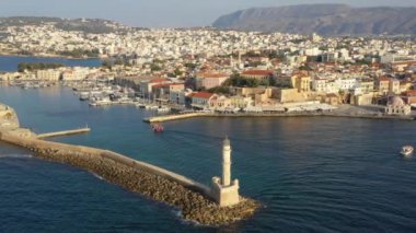 Güzel renklerle Chania pitoresk eski liman girişinde ikonik Venedik deniz feneri havadan drone video, Girit adası, Yunanistan. Chania'da deniz feneri. Chania şehrinin deniz feneri.