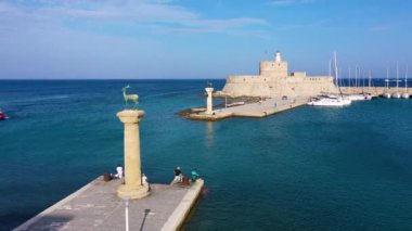 Geyik heykeli olan Mandraki limanı, Heykelin durduğu yer ve Aziz Niklas kalesi. Rodos, Yunanistan. Rodos, Rodos, Yunanistan Heykeli 'nin yerine Hirschkuh heykeli