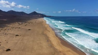 Uçsuz bucaksız ufku olan harika Coffee Plajı. Arka planda volkanik tepeler ve Atlantik Okyanusu. Coffee Beach, Fuerteventura, Kanarya Adaları, İspanya. Playa de Coffee, Fuerteventura, Kanarya Adaları.