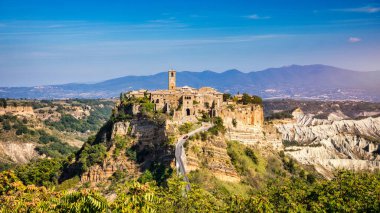 The famous Civita di Bagnoregio on a sunny day. Province of Viterbo, Lazio, Italy. Medieval town on the mountain, Civita di Bagnoregio, popular touristic stop at Tuscany, Italy.