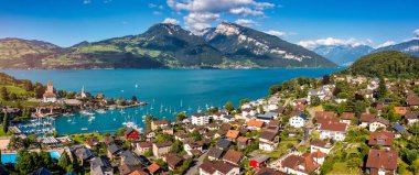 Günbatımında İsviçre 'nin Bern kantonunda bulunan Thun Gölü kıyısındaki Spiez Kilisesi ve kasaba manzarası, Spiez, İsviçre. İsviçre 'nin Bern kantonundaki Thun Gölü kıyısındaki Spiez şehri..