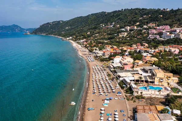 Yunanistan 'ın Korfu adasındaki Agios Gordios egzotik plajı. Agios Gordios plajı, Korfu adası, Yunanistan. Agios Gordios plajının panoramik manzarası, kumlu deniz kıyıları, plaj şemsiyeleri ve şezlonglar..