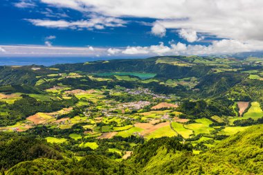 Miradouro de Santa Iria 'dan Azores' deki So Miguel adasının görüntüsü. Manzara, kuzey kıyı şeridinin bir kısmını kayalıklar ve uçurumun üzerindeki yeşil alanlarla gösteriyor. Azores, Sao Miguel, Portekiz