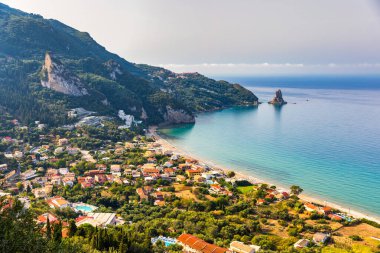 Yunanistan 'ın Korfu adasındaki Agios Gordios egzotik plajı. Agios Gordios plajı, Korfu adası, Yunanistan. Agios Gordios plajının panoramik manzarası, kumlu deniz kıyıları, plaj şemsiyeleri ve şezlonglar..