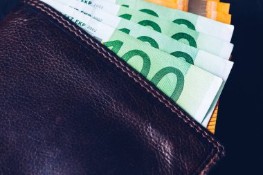 M-cüzdan ile Euro banknot. M-cüzdan siyah bir arka plan üzerinde para kazanın. Euro para deri cüzdan.