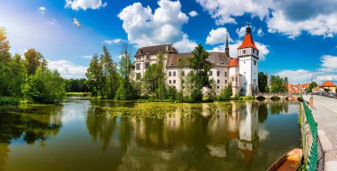 Strakonice yakınlarındaki Blatna kalesi, Güney Bohemya, Çek Cumhuriyeti. Ortaçağ Blatna su kalesinin havadan görünüşü, Çek Cumhuriyeti 'nin Güney Bohem Bölgesi' ndeki park ve gölleri, Blatna 'yı kuşattı..