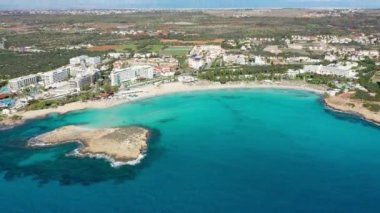 Kıbrıs Rum Kesimi 'nin Ayia Napa kentindeki güzel Nissi plajının hava manzarası. Kıbrıs 'ın Ayia Napa kentindeki Nissi plajı. Kıbrıs Rum Kesimi 'nin Aiya Napa kentindeki gök mavisi bir su manzarası ve Nissi plajı.