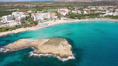 Kıbrıs Rum Kesimi 'nin Ayia Napa kentindeki güzel Nissi plajının hava manzarası. Kıbrıs 'ın Ayia Napa kentindeki Nissi plajı. Kıbrıs Rum Kesimi 'nin Aiya Napa kentindeki gök mavisi bir su manzarası ve Nissi plajı.