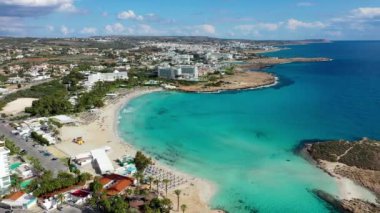 Kıbrıs Rum Kesimi 'nin Ayia Napa kentindeki güzel Nissi plajının hava manzarası. Kıbrıs 'ın Ayia Napa kentindeki Nissi plajı. Kıbrıs Rum Kesimi 'nin Aiya Napa kentindeki gök mavisi bir su manzarası ve Nissi plajı.