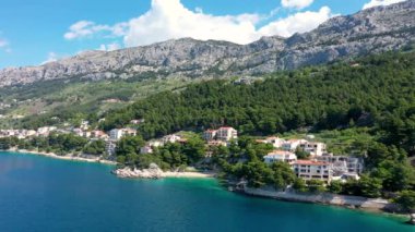 Hırvatistan, Makarska Riviera 'da güzel Brela. Adriyatik Denizi, turkuaz, temiz su ve beyaz kumla. Hırvatistan 'ın Makarska Riviera, Dalmaçya bölgesindeki Brela sahili ve liman manzarası.