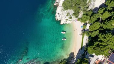 Hırvatistan 'ın Makarska Riviera kentinin Brela kentindeki güzel Podrace plajının muhteşem hava manzarası. Hırvatistan 'ın Makarska Riviera, Brela ve Dalmaçya bölgesindeki Podrace plajı ve liman manzarası.