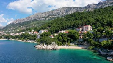 Hırvatistan, Makarska Riviera 'da güzel Brela. Adriyatik Denizi, turkuaz, temiz su ve beyaz kumla. Hırvatistan 'ın Makarska Riviera, Dalmaçya bölgesindeki Brela sahili ve liman manzarası.