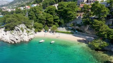 Hırvatistan, Makarska Riviera 'da güzel Brela. Adriyatik Denizi, turkuaz, temiz su ve beyaz kumla. Hırvatistan 'ın Makarska Riviera, Dalmaçya bölgesindeki Brela sahili ve liman manzarası.