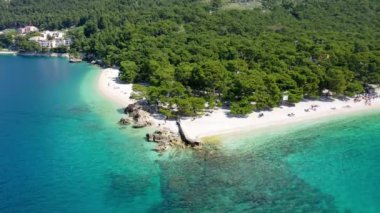 Hırvatistan, Makarska Riviera 'da güzel Brela. Adriyatik Denizi, turkuaz, temiz su ve beyaz kumla. Hırvatistan 'ın Makarska Riviera, Dalmaçya bölgesindeki Brela sahili ve liman manzarası.