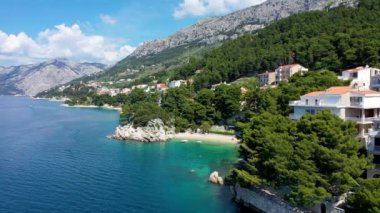 Hırvatistan, Makarska Riviera 'da güzel Brela. Adriyatik Denizi, turkuaz, temiz su ve beyaz kumla. Hırvatistan 'ın Makarska Riviera, Dalmaçya bölgesindeki Brela sahili ve liman manzarası.