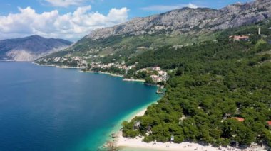 Hırvatistan 'ın Makarska Riviera kentinin Brela kentindeki Punta Rata plajının güzel hava manzarası. Hırvatistan 'ın Makarska Riviera, Brela, Dalmaçya bölgesindeki Punta Rata plajı ve liman manzarası.