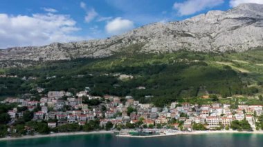 Hırvatistan, Makarska Riviera 'da güzel Brela. Adriyatik Denizi, turkuaz, temiz su ve beyaz kumla. Hırvatistan 'ın Makarska Riviera, Dalmaçya bölgesindeki Brela sahili ve liman manzarası.