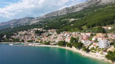 Hırvatistan, Makarska Riviera 'da güzel Brela. Adriyatik Denizi, turkuaz, temiz su ve beyaz kumla. Hırvatistan 'ın Makarska Riviera, Dalmaçya bölgesindeki Brela sahili ve liman manzarası.