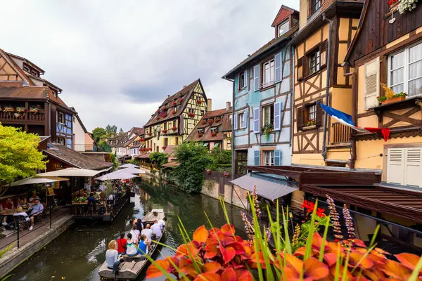 Colmar, Fransa - 27 Temmuz 2018: Colmar, Alsace, Fransa. Renkli binalar, kanallar ve çiçekler. Colmar, Fransa. Petite Venedik, su kanalı ve geleneksel yarı ahşap evler.