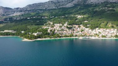 Hırvatistan, Makarska Riviera 'da güzel Brela. Adriyatik Denizi, turkuaz, temiz su ve beyaz kumla. Hırvatistan 'ın Makarska Riviera, Dalmaçya bölgesindeki Brela sahili ve liman manzarası.