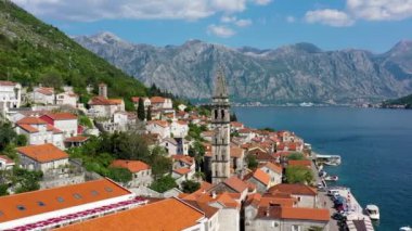 Karadağ 'ın ünlü Kotor Koyu' ndaki tarihi Perast kasabasının mavi gökyüzü ve yaz aylarında bulutlarla dolu güneşli güzel bir günü. Karadağ 'ın Kotor Körfezi' ndeki tarihi Perast kenti yazın.